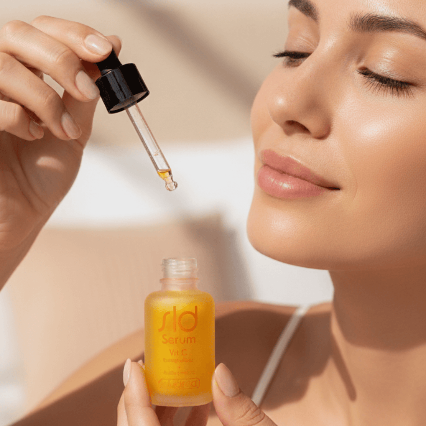 Mujer aplicando SLD Serum Vitamina C encapsulada de Saludirect en el rostro, tratamiento antioxidante que revitaliza y aporta luminosidad.